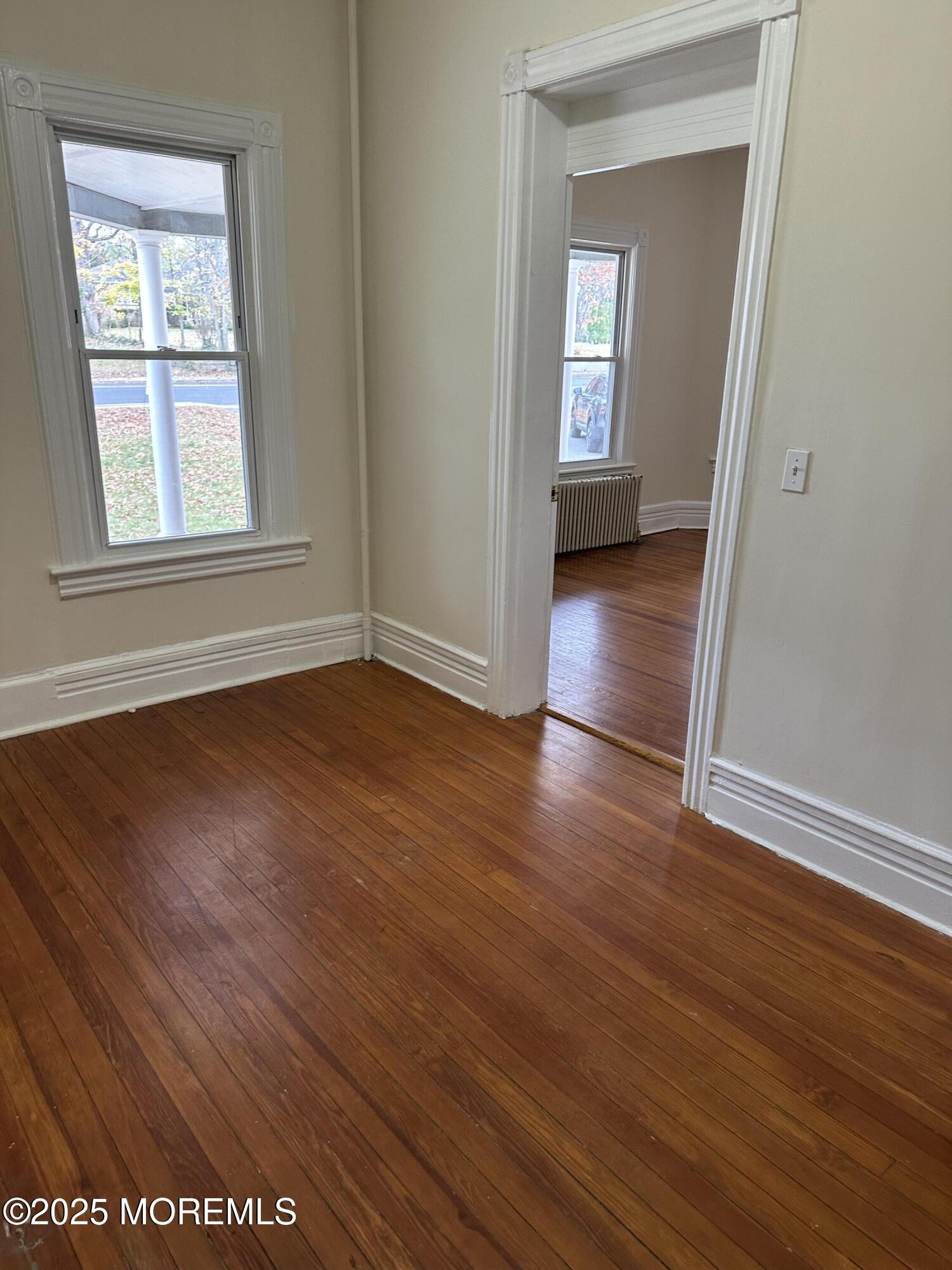 348 Cedar Avenue, Unit 3 Long Branch, NJ 07740 - Photo 5 of 9 an empty room with wooden floor and windows