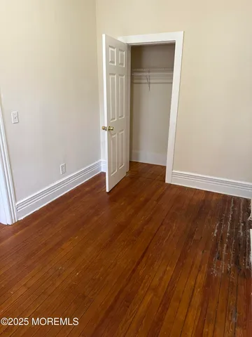 an empty room with wooden floor and closet