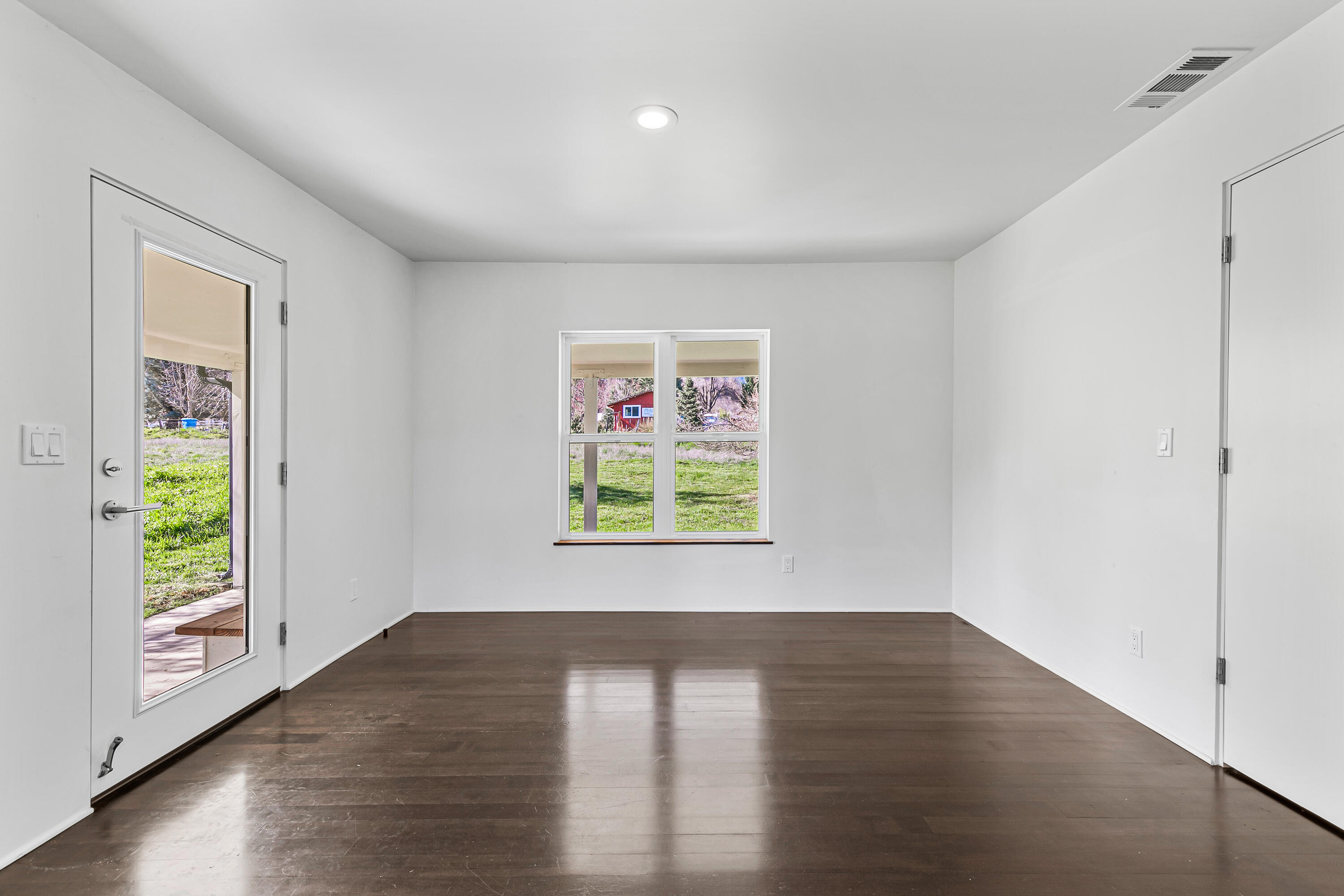 593 Crowson Road Ashland, OR 97520 - Photo 18 of 36 a view of an empty room with wooden floor and a window