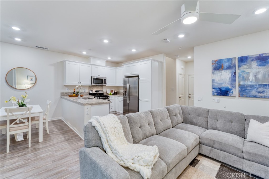 a living room with furniture kitchen and a wooden floor