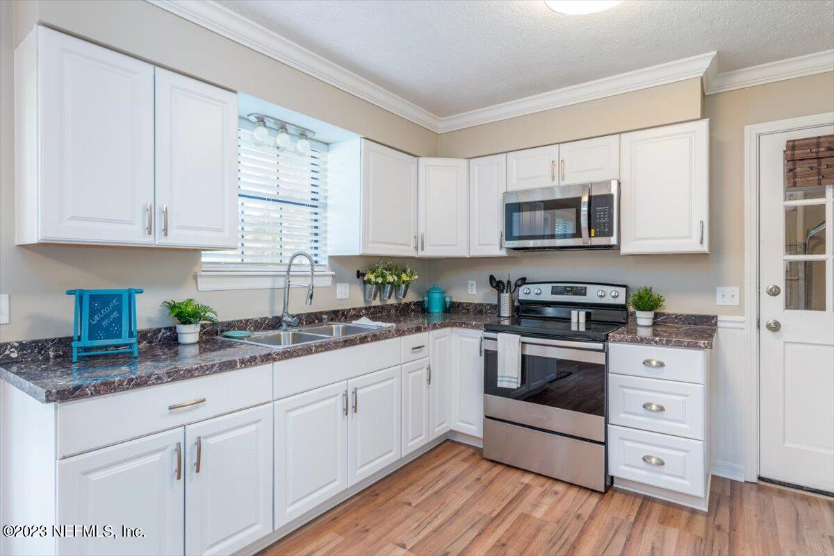 1575 Hardy Padgett Road Jacksonville, FL 32234 - Photo 11 of 43 a kitchen with granite countertop white cabinets and stainless steel appliances