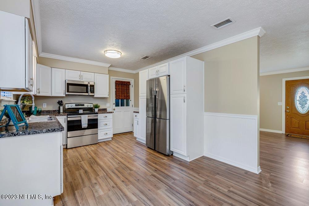 1575 Hardy Padgett Road Jacksonville, FL 32234 - Photo 12 of 43 a kitchen with granite countertop a refrigerator and a stove top oven