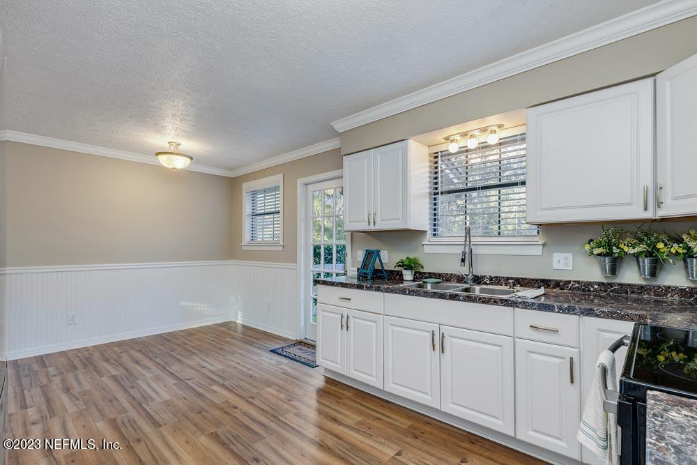 1575 Hardy Padgett Road Jacksonville, FL 32234 - Photo 13 of 43 a kitchen with granite countertop white cabinets and a window