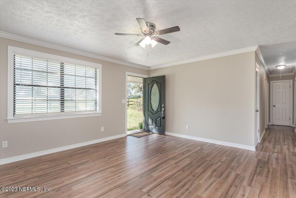 1575 Hardy Padgett Road Jacksonville, FL 32234 - Photo 5 of 43 a view of an empty room with wooden floor and a window