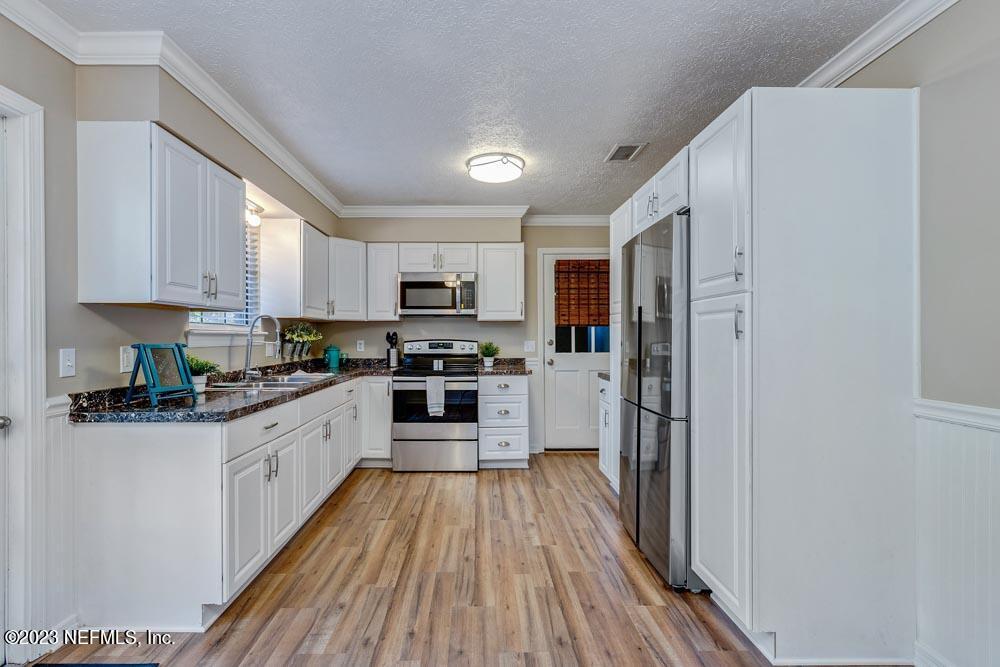 1575 Hardy Padgett Road Jacksonville, FL 32234 - Photo 10 of 43 a kitchen with stainless steel appliances a refrigerator sink and cabinets