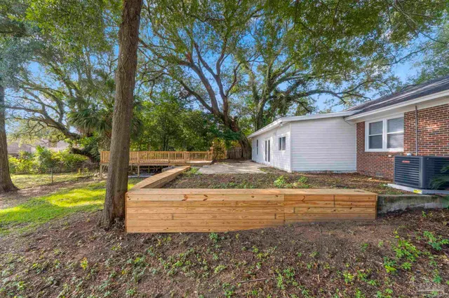 a view of a house with backyard and trees