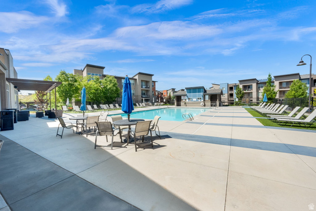 7713 Navarro View Court Midvale, UT 84047 - Photo 29 of 41 Outdoor swimming pool with surrounding concrete decking, artificial turf, and multiple lounge chairs