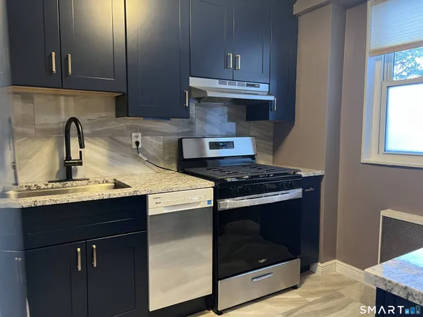 a kitchen with stainless steel appliances a sink stove and cabinets