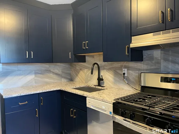 a kitchen with granite countertop a stove and a cabinets