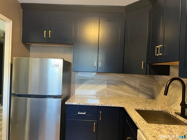 a kitchen with a refrigerator and a sink