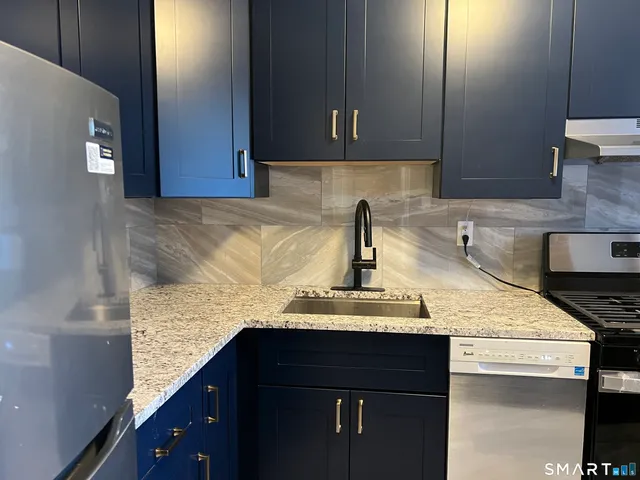 a kitchen with granite countertop a sink and cabinets