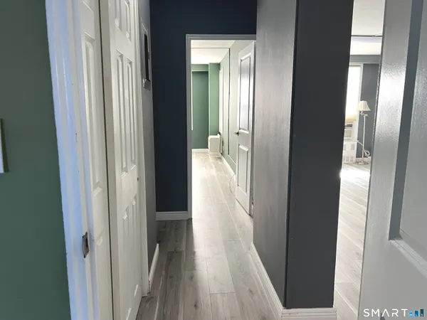 a view of a hallway with wooden floor