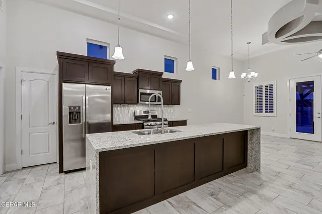 a kitchen with stainless steel appliances a sink refrigerator and microwave