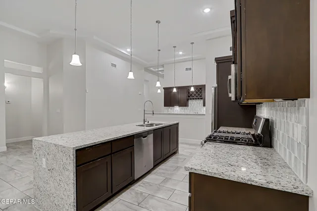 a kitchen with kitchen island granite countertop stainless steel appliances lots of counter top space