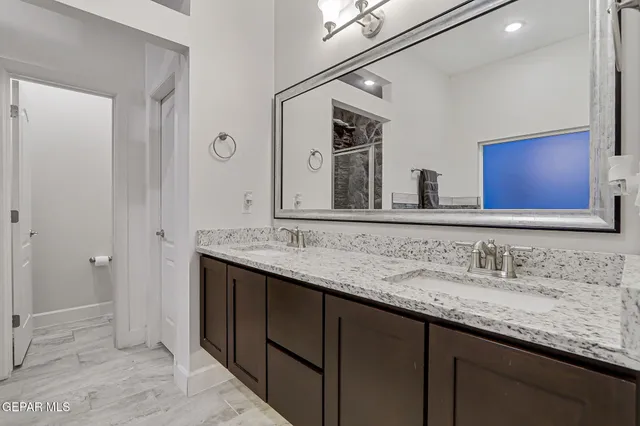 a bathroom with a granite countertop sink and a mirror