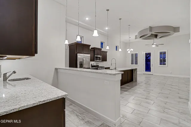 a kitchen with kitchen island a sink stainless steel appliances and a counter top space