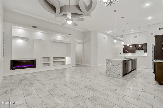 a large room with stainless steel appliances kitchen island granite countertop a sink and cabinets