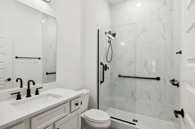 a bathroom with a sink toilet vanity and shower