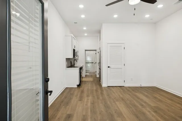 wooden floor in an empty room with a kitchen