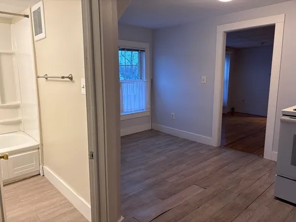 a view of a hallway with wooden floor and closet area