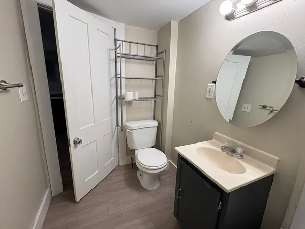 a bathroom with a toilet sink and mirror