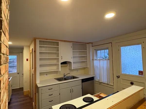 a kitchen with a sink cabinets and wooden floor