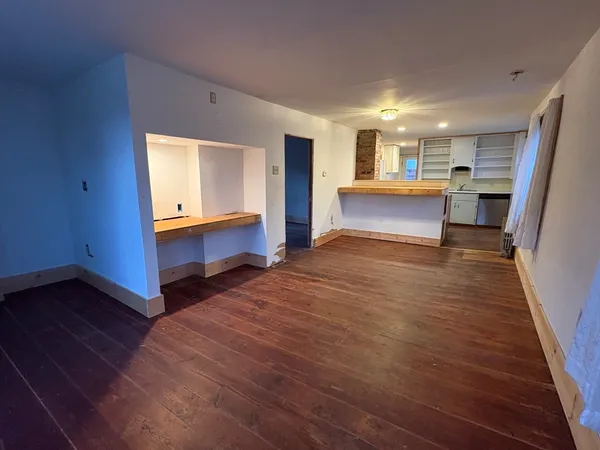 a view of kitchen and hall with wooden floor