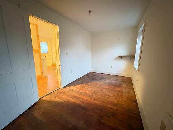 a view of empty room with wooden floor