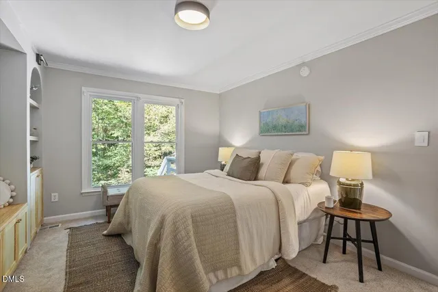 a bedroom with a bed and painting on the wall