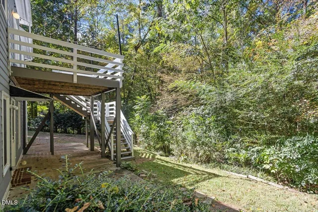 a view of a house with a yard and large tree