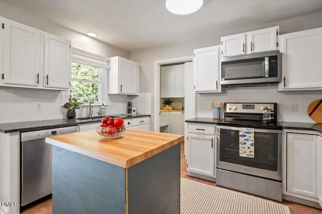 a kitchen with stainless steel appliances a stove microwave and sink