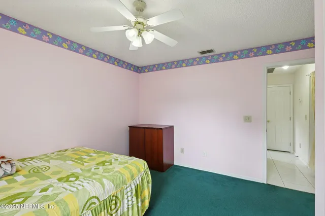 a bedroom with a bed and a chandelier fan