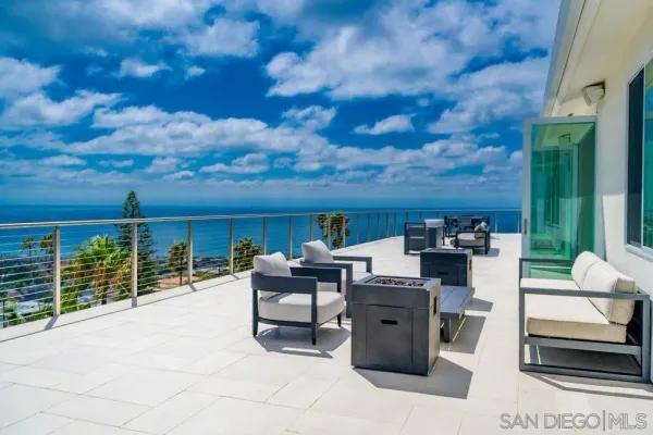 a view of a terrace with furniture and a yard