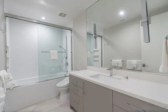 a bathroom with a sink a toilet and shower