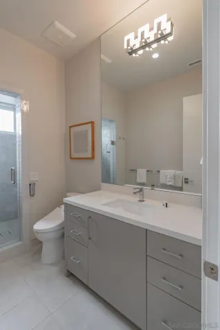 a bathroom with a double vanity sink mirror and toilet