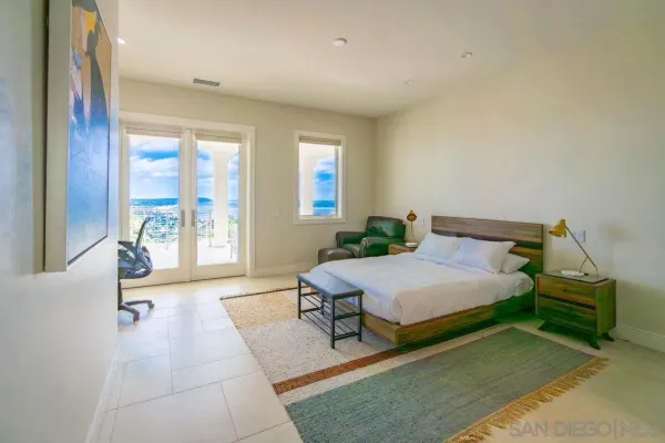 a bedroom with a bed and large windows