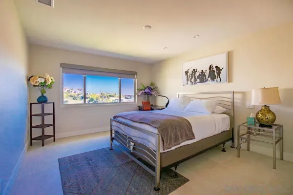 a spacious bedroom with a bed and a window