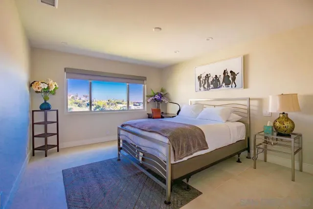 a spacious bedroom with a bed and a window