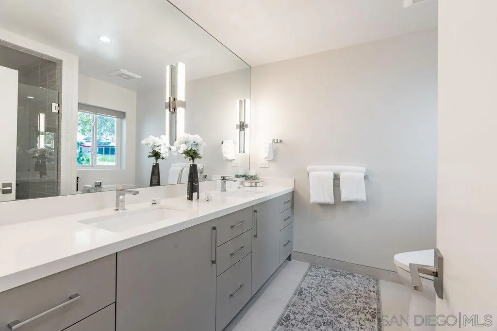 1001 La Jolla Rancho Road La Jolla, CA 92037 - Photo 40 of 47 a bathroom with a double vanity sink toilet and a mirror