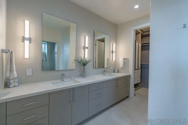 a spacious bathroom with a double vanity sink mirror and next to a window