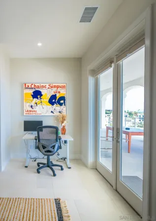 a view of a workspace with furniture and a window