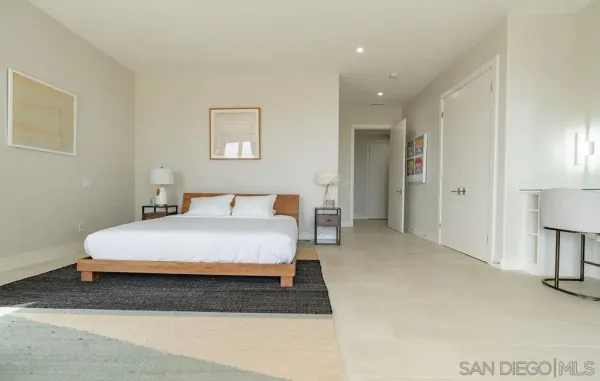 a spacious bedroom with a bed and a lamp
