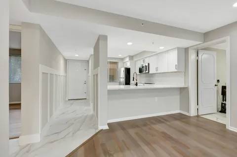 a view of kitchen electric appliances cabinets and a sink
