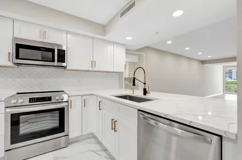 a kitchen with stainless steel appliances granite countertop a sink a stove a microwave and cabinets