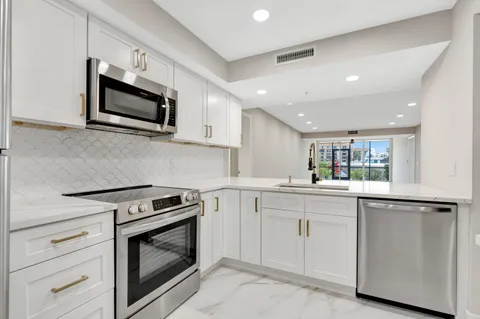 a kitchen with white cabinets stainless steel appliances and sink