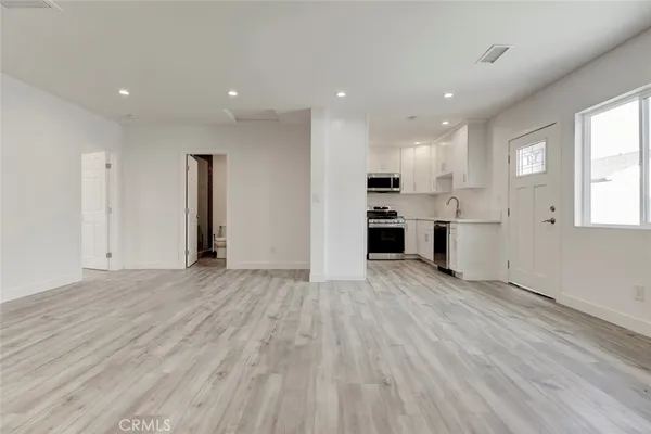 an empty room with kitchen appliances and windows