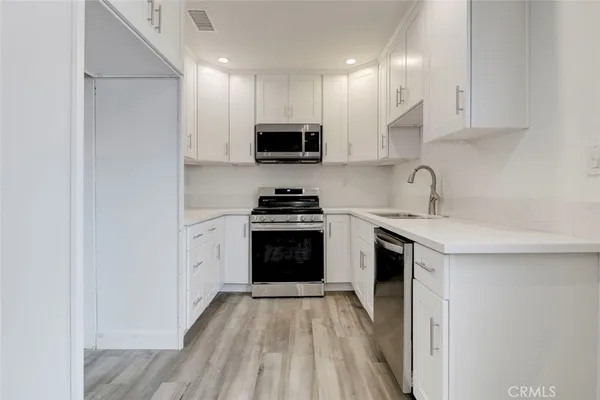 a kitchen with sink a microwave and cabinets