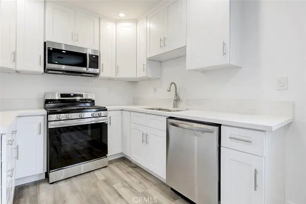 a kitchen with white cabinets and stainless steel appliances