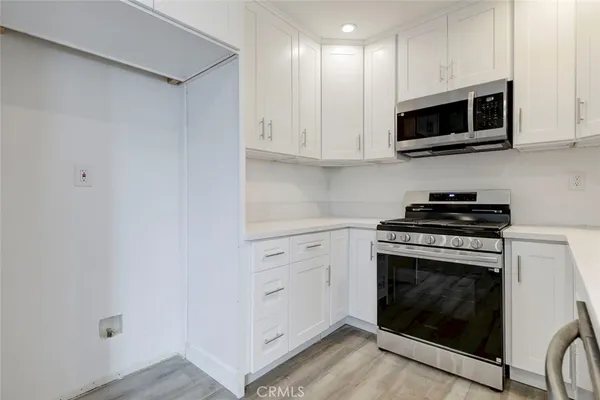 a kitchen with stainless steel appliances granite countertop a stove a microwave and cabinets