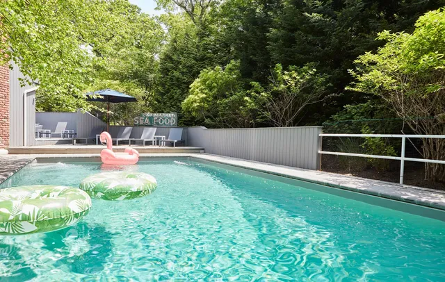 a backyard of a house with table and chairs in a yard